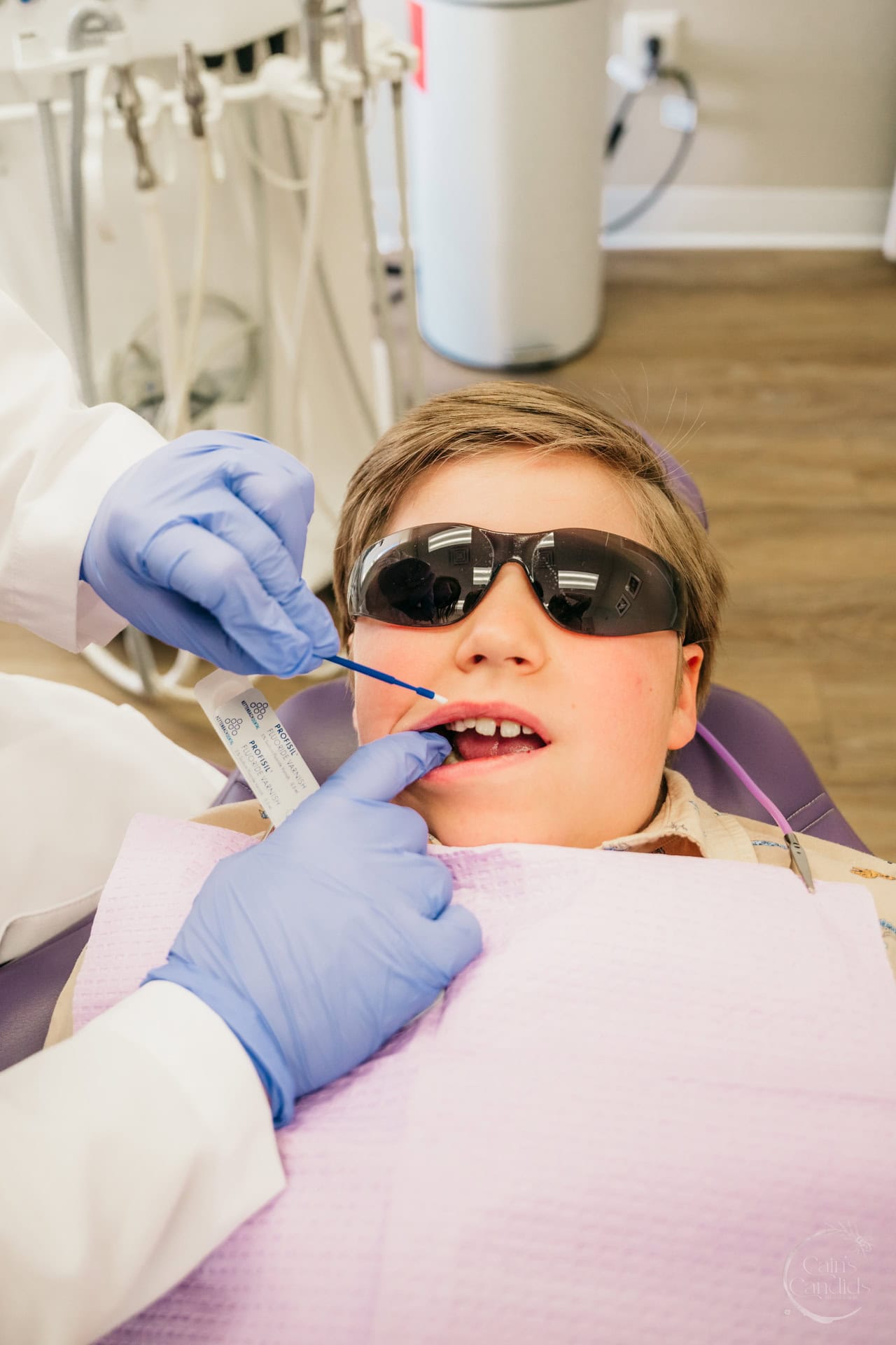 Dental professional providing hygiene care to a child.