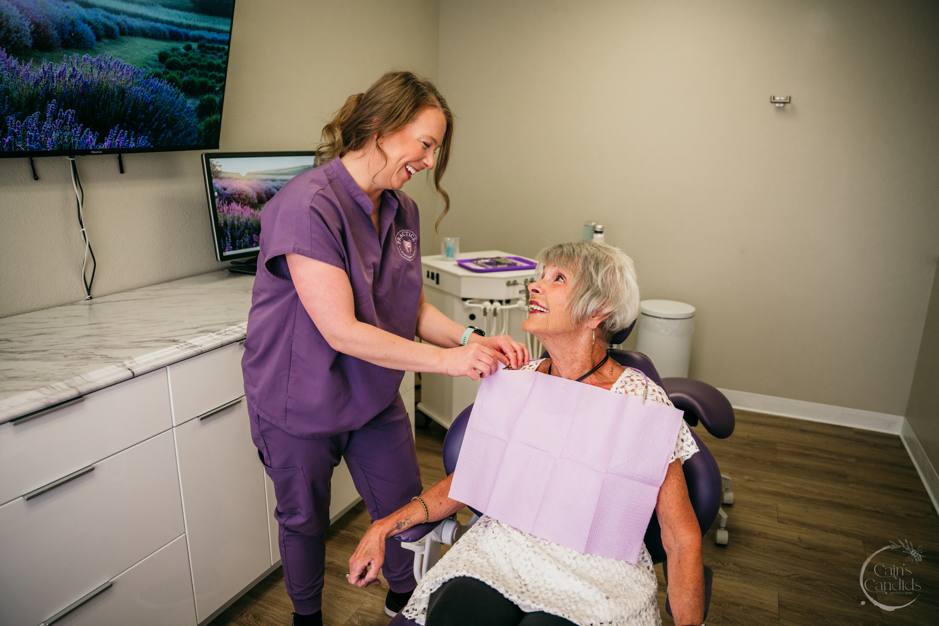 A dental hygienist providing a fluoride treatment to an older adult patient.
