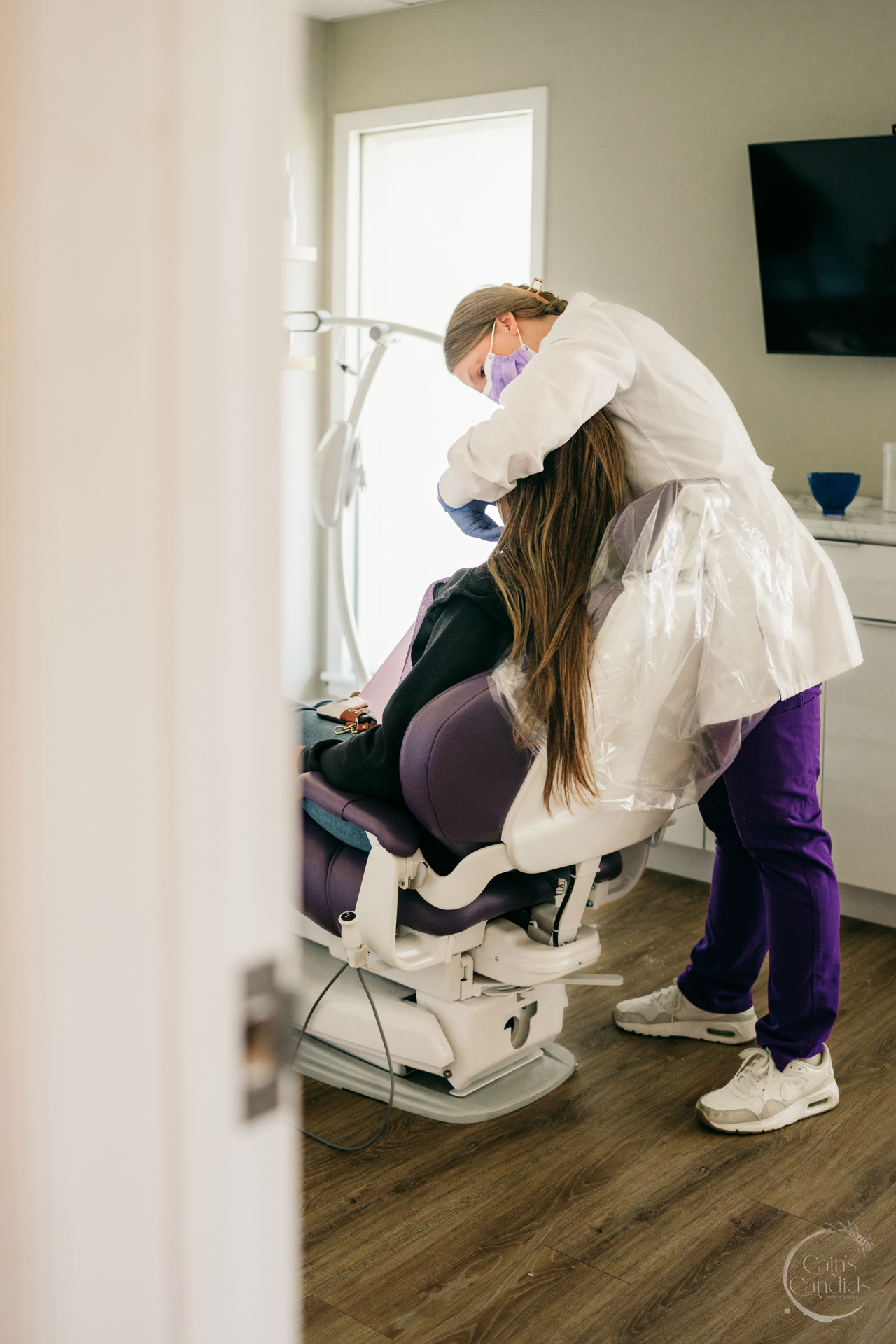 A smiling dental hygienist providing care to a patient.