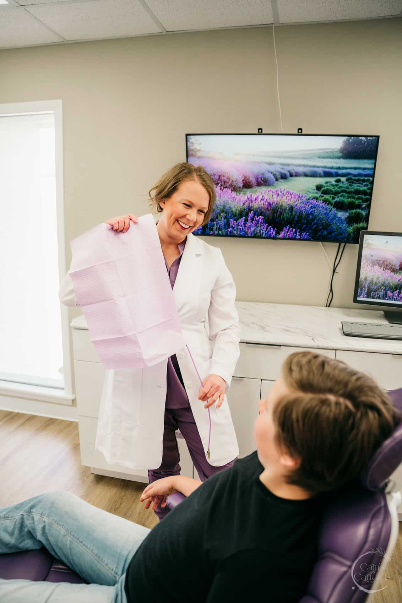 A dental hygienist working with a patient in a clinic while a family looks on, symbolizing military spouse adaptability.