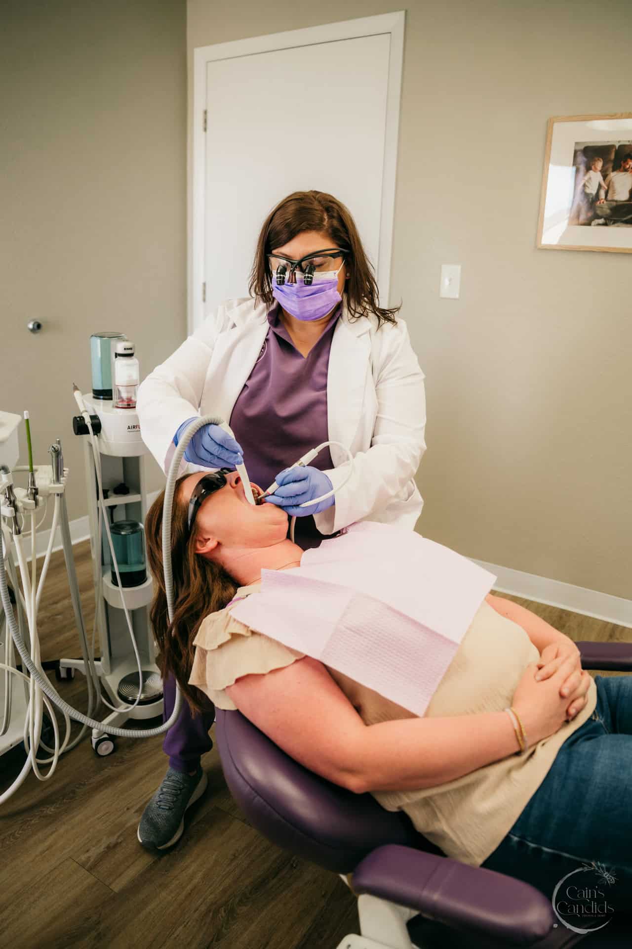 A dentist demonstrating proper dental hygiene techniques to a patient in Colorado Springs.