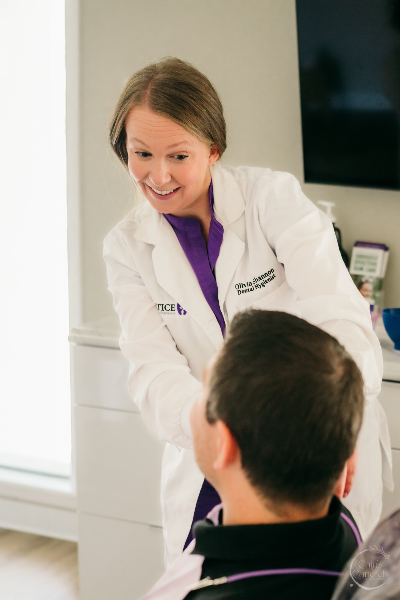 Dental hygienist performing an oral examination at a dental clinic.